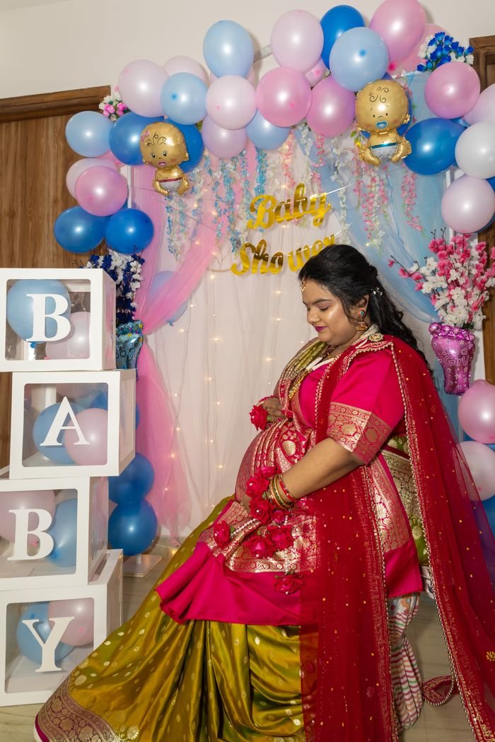 Crafting Captivating Headlines: Your awesome post title goes here Expectant mother at a vibrant baby shower with colorful decor and traditional attire.
